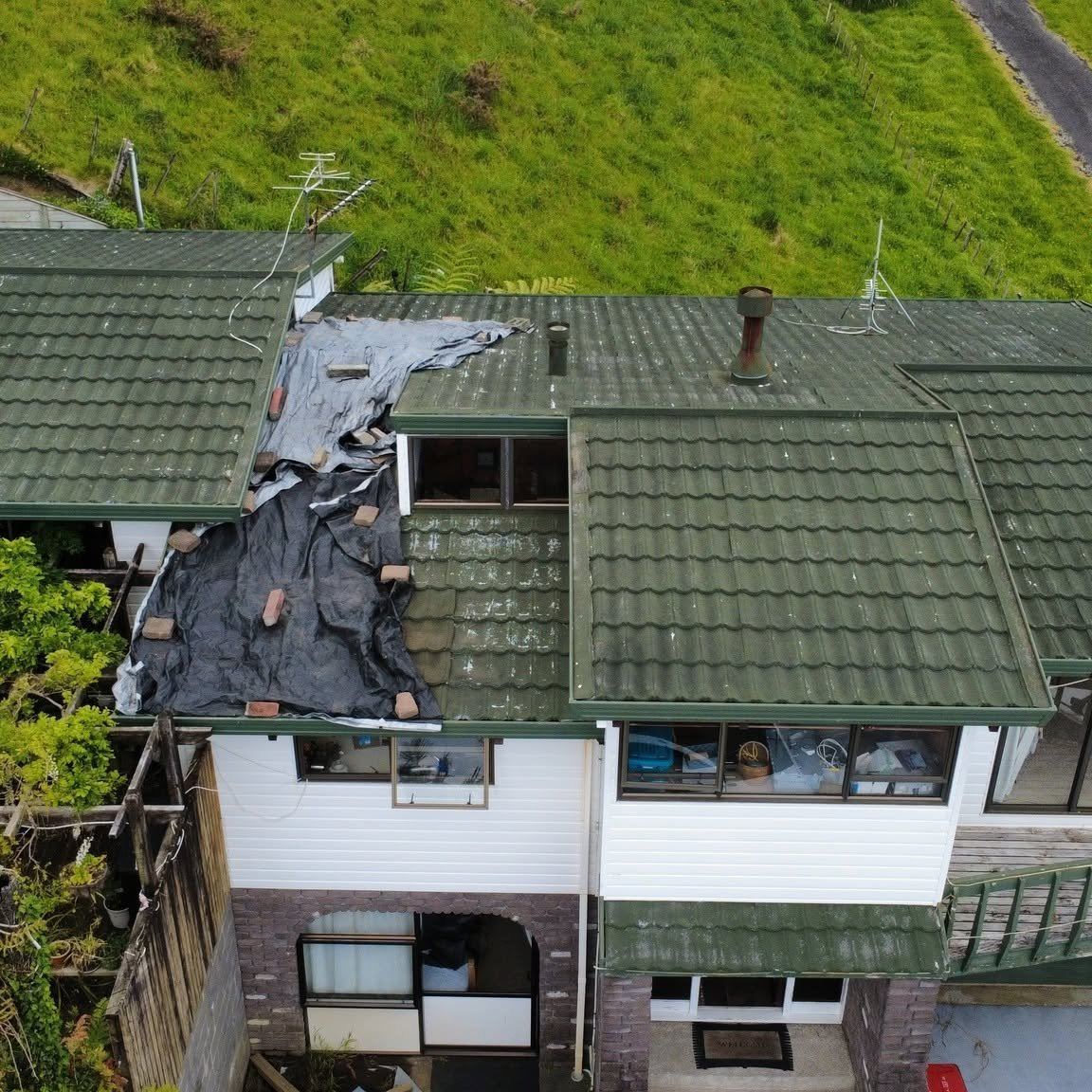 Old asbestos tile roof before replacement, covered with protective tarps